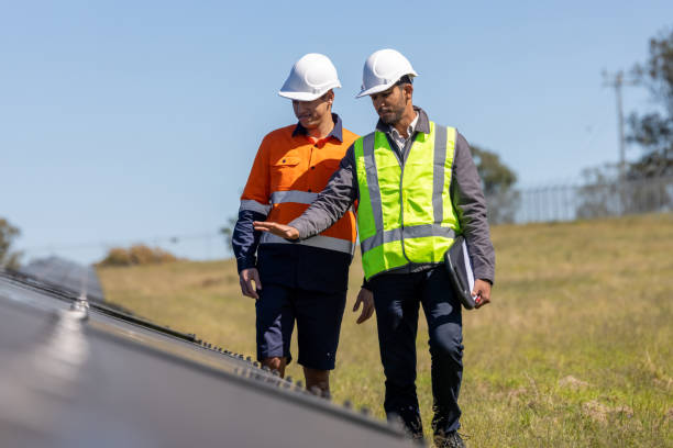 Indian-Australian Engineer and Aboriginal Australian Apprentice Working Together On Solar Farm Installation